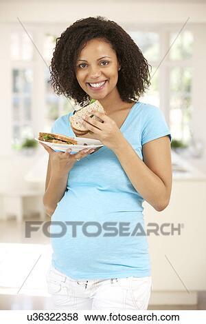 Pregnant woman eating sandwich View Large Photo Image Stock Photo - Pregnant woman eating sandwich. Fotosearch