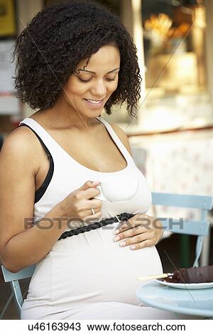 Pregnant woman sitting outside café View Large Photo Image Stock Image - Pregnant woman sitting outside café. Fotosearch