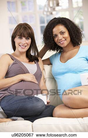 Stock Photo - Pregnant women relaxing together. Fotosearch