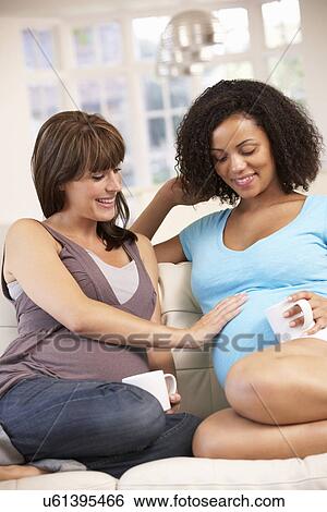 Stock Photograph - Pregnant women relaxing together. Fotosearch