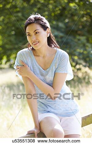 Pretty Asian Woman Sitting On Fence In Countryside View Large Photo Image Stock Photo - Pretty Asian Woman Sitting On Fence In Countryside. Fotosearch