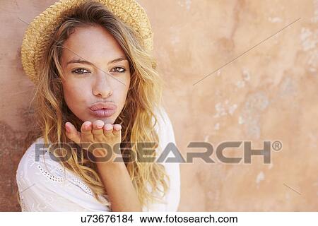 Picture - Pretty Young Woman Blowing Kiss Towards Camera. Fotosearch
