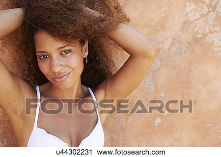 Stock Image - Pretty Young Woman Wearing Swimsuit Leaning Against Wall. Fotosearch