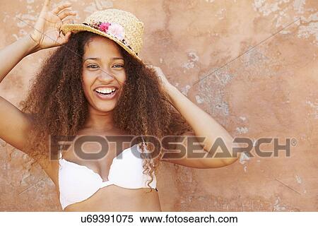 Stock Photography - Pretty Young Woman Wearing Swimsuit Leaning Against Wall. Fotosearch