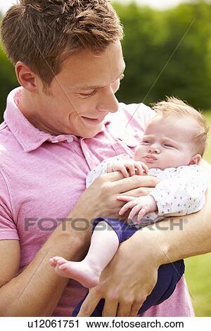 Proud Father Holding Baby Daughter In Garden View Large Photo Image Stock Image - Proud Father Holding Baby Daughter In Garden. Fotosearch