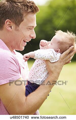 Proud Father Holding Baby Daughter In Garden View Large Photo Image Stock Image - Proud Father Holding Baby Daughter In Garden. Fotosearch