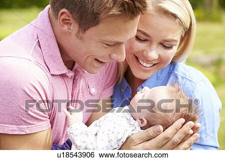 Proud Parents Holding Baby Daughter In Garden View Large Photo Image Stock Photograph - Proud Parents Holding Baby Daughter In Garden. Fotosearch