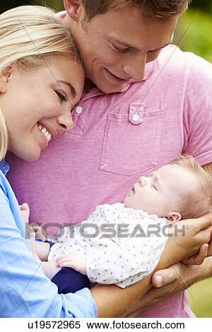 Proud Parents Holding Baby Daughter In Garden View Large Photo Image Stock Photography - Proud Parents Holding Baby Daughter In Garden. Fotosearch