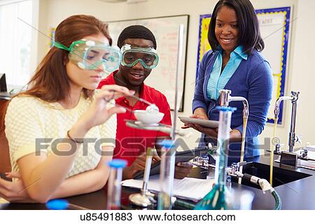 Stock Image - Pupils Carrying Out Experiment In Science Class. Fotosearch