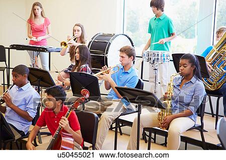 Stock Image - Pupils Playing Musical Instruments In School Orchestra. Fotosearch