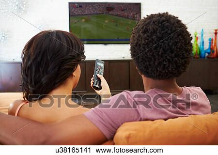 Rear View Of Couple Sitting On Sofa Watching TV Together View Large Photo Image Stock Image - Rear View Of Couple Sitting On Sofa Watching TV Together. Fotosearch