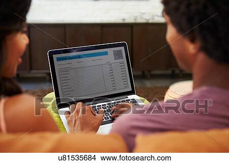 Rear View Of Couple Using Online Banking On Laptop View Large Photo Image Picture - Rear View Of Couple Using Online Banking On Laptop. Fotosearch