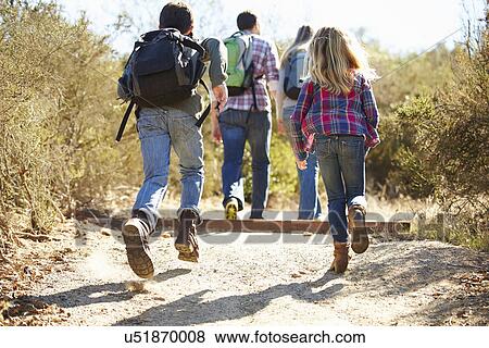Rear View Of Family Hiking In Countryside Wearing Backpacks View Large Photo Image Stock Photo - Rear View Of Family Hiking In Countryside Wearing Backpacks. Fotosearch