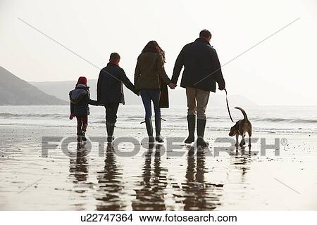 Rear View Of Family Walking Along Winter Beach With Dog View Large Photo Image Picture - Rear View Of Family Walking Along Winter Beach With Dog. Fotosearch