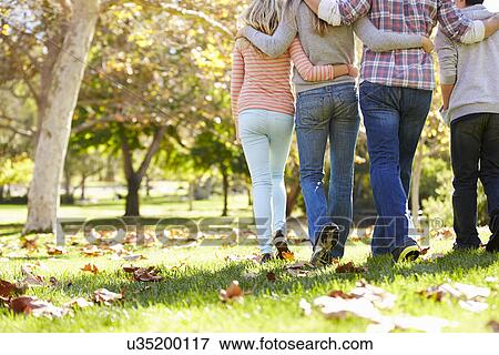 Stock Photo - Rear View Of Family Walking Through Autumn Woodland. Fotosearch