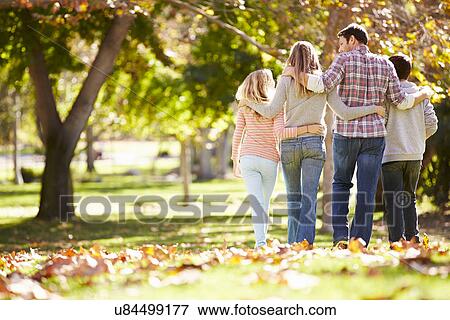 Stock Photo - Rear View Of Family Walking Through Autumn Woodland. Fotosearch