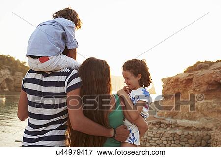 Rear View Of Family Watching Sunset Over Harbour View Large Photo Image Stock Photo - Rear View Of Family Watching Sunset Over Harbour. Fotosearch