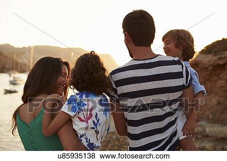 Rear View Of Family Watching Sunset Over Harbour View Large Photo Image Stock Photo - Rear View Of Family Watching Sunset Over Harbour. Fotosearch