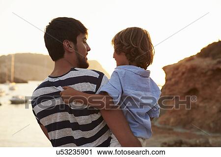 Rear View Of Father And Son Watching Sunset Over Harbour View Large Photo Image Stock Image - Rear View Of Father And Son Watching Sunset Over Harbour. Fotosearch
