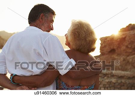 Rear View Of Senior Couple Watching Sunset Over Port View Large Photo Image Stock Photograph - Rear View Of Senior Couple Watching Sunset Over Port. Fotosearch