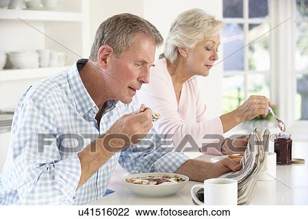 Stock Image - Retired couple eating breakfast. Fotosearch