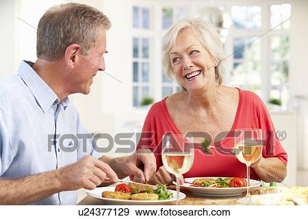 Stock Photo - Retired couple enjoying meal at home. Fotosearch
