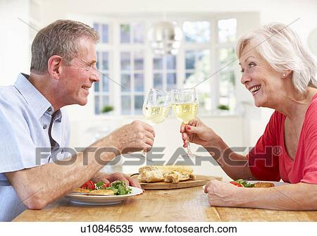 Stock Photography - Retired couple enjoying meal at home. Fotosearch
