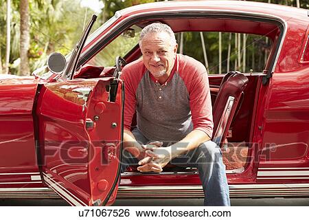 Stock Photograph - Retired Senior Man Sitting In Restored Classic Car. Fotosearch