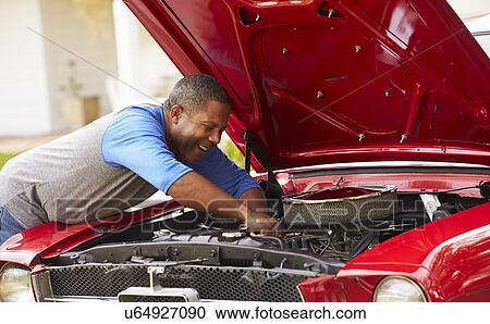 Stock Image - Retired Senior Man Working On Restored Car . Fotosearch