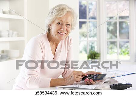 Retired woman with household bills View Large Photo Image Stock Photograph - Retired woman with household bills. Fotosearch