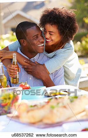 Stock Image - Romantic Couple Enjoying Outdoor Meal In Garden. Fotosearch