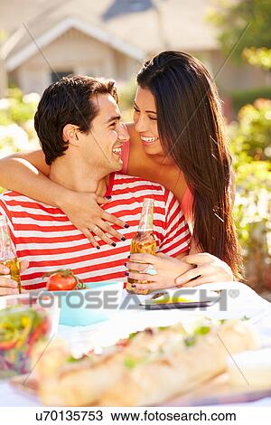 Stock Image - Romantic Couple Enjoying Outdoor Meal In Garden. Fotosearch