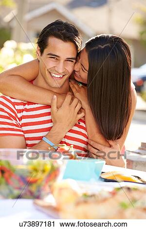 Stock Image - Romantic Couple Enjoying Outdoor Meal In Garden. Fotosearch