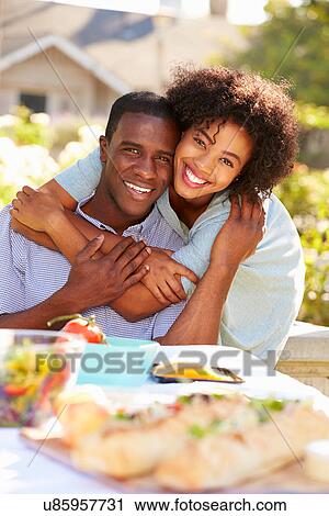 Romantic Couple Enjoying Outdoor Meal In Garden View Large Photo Image Stock Image - Romantic Couple Enjoying Outdoor Meal In Garden. Fotosearch