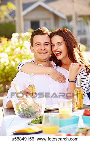 Stock Photograph - Romantic Couple Enjoying Outdoor Meal In Garden. Fotosearch