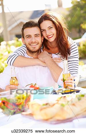 Stock Photography - Romantic Couple Enjoying Outdoor Meal In Garden. Fotosearch