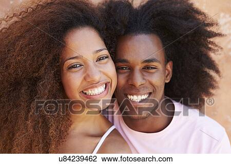 Stock Image - Romantic Couple On Holiday Together Posing By Wall. Fotosearch