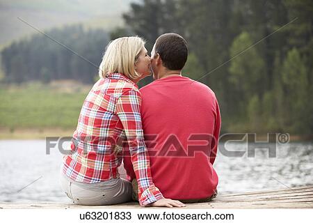 Romantic couple sitting on a jetty View Large Photo Image Stock Image - Romantic couple sitting on a jetty. Fotosearch