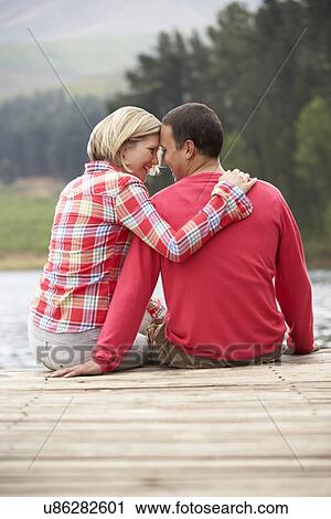 Romantic couple sitting on a jetty View Large Photo Image Stock Image - Romantic couple sitting on a jetty. Fotosearch
