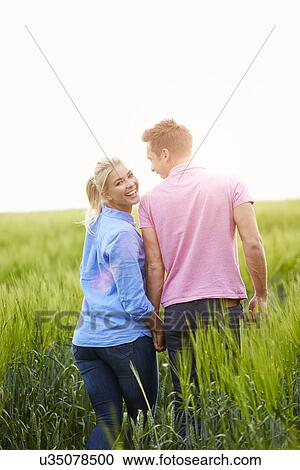 Romantic Couple Walking In Field Holding Hands View Large Photo Image Stock Image - Romantic Couple Walking In Field Holding Hands. Fotosearch