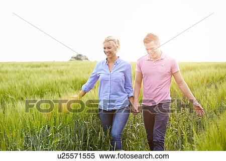 Romantic Couple Walking In Field Holding Hands View Large Photo Image Stock Photography - Romantic Couple Walking In Field Holding Hands. Fotosearch
