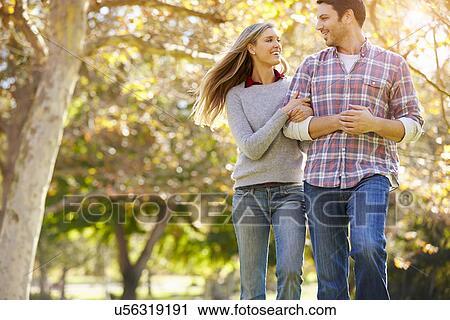 Stock Image - Romantic Couple Walking Through Autumn Woodland. Fotosearch