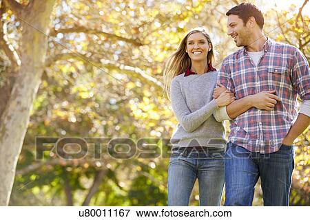 Romantic Couple Walking Through Autumn Woodland View Large Photo Image Stock Photo - Romantic Couple Walking Through Autumn Woodland. Fotosearch