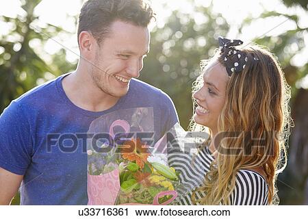 Stock Image - Romantic Man Giving Woman Bunch Of Flowers. Fotosearch