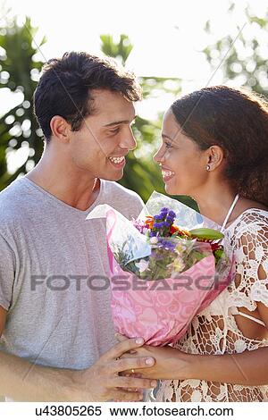 Stock Photography - Romantic Man Giving Woman Bunch Of Flowers. Fotosearch