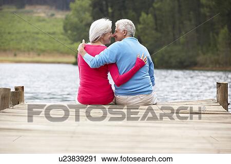 Romantic senior couple sitting on a jetty View Large Photo Image Stock Image - Romantic senior couple sitting on a jetty. Fotosearch