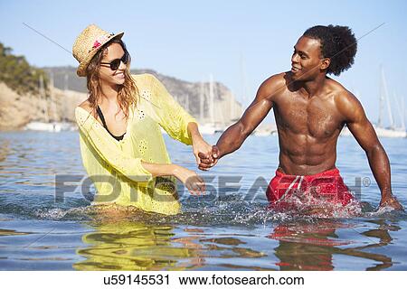 Stock Image - Romantic Young Couple Having Fun In Sea Together. Fotosearch