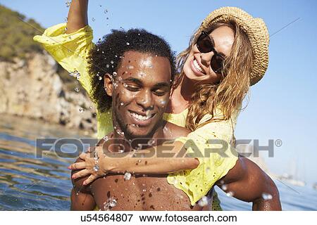 Stock Photo - Romantic Young Couple Having Fun In Sea Together. Fotosearch