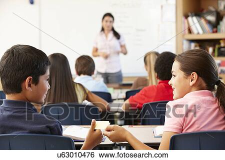 Schoolchildren passing note in class View Large Photo Image Stock Photograph - Schoolchildren passing note in class. Fotosearch