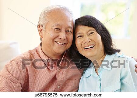 Senior Asian Couple Sitting On Sofa At Home Together View Large Photo Image Stock Photography - Senior Asian Couple Sitting On Sofa At Home Together. Fotosearch